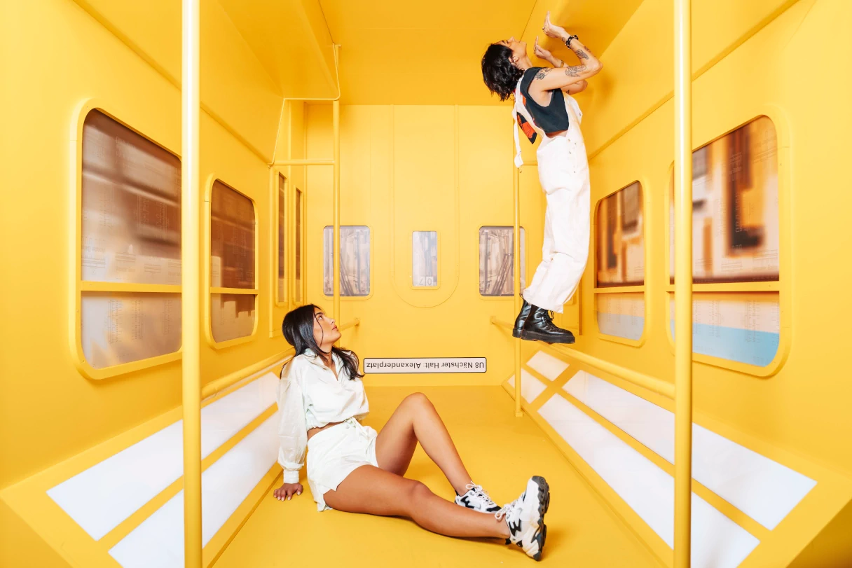 zwei Personen stehen über Kopf in einer U-Bahn, Illusion, Studio of Wonders