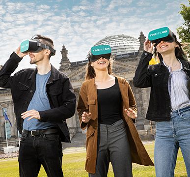 TimeRide, group of friends stands in front of Reichstag, have virtual reality glasses on