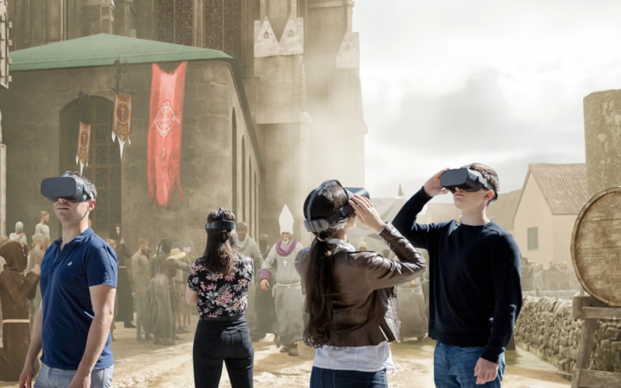 2 junge Frauen und 2 junge Männer mit Vr-Brillen stehen locker verteilt in einem historisch virtuellen Bild