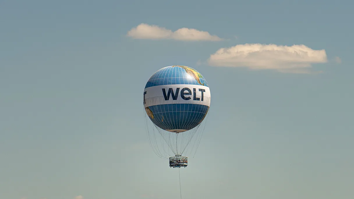 Weltballon Berlin, schwebt in der Luft, zwei kleine weißen Wolken am blauen Himmel und sonst nichts weiter außer der Ballon