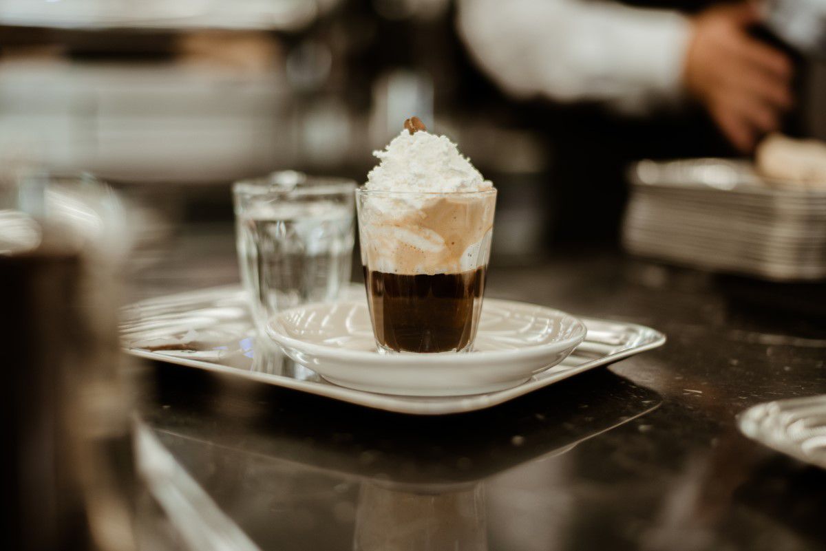 Cafe Hawelka, Glas mit Kaffee und Schlagoberst, Sahne, auf einem silbernen Tablett, ein Glas Leitungswasser steht ebenfalls daneben