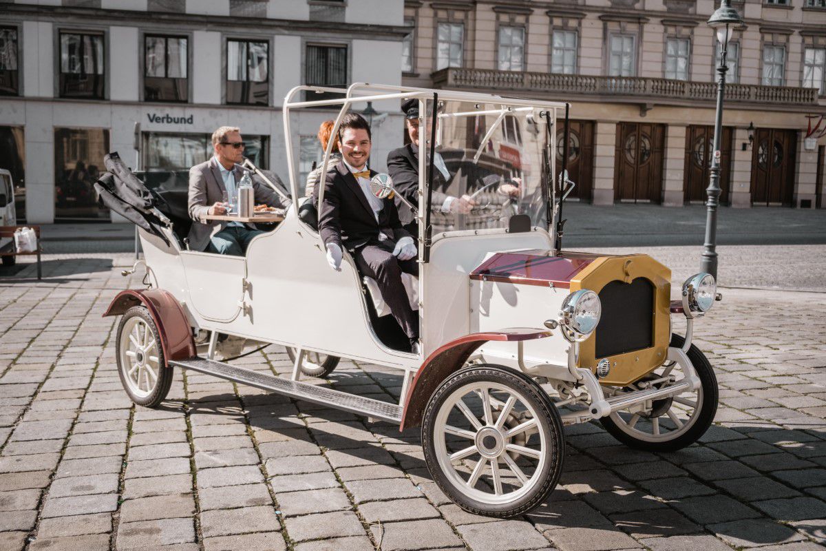 Wien mal anders, Tour mit dem City Oldtimer, sonniger Platz, Oldtimer ist mit Gästen gefüllt