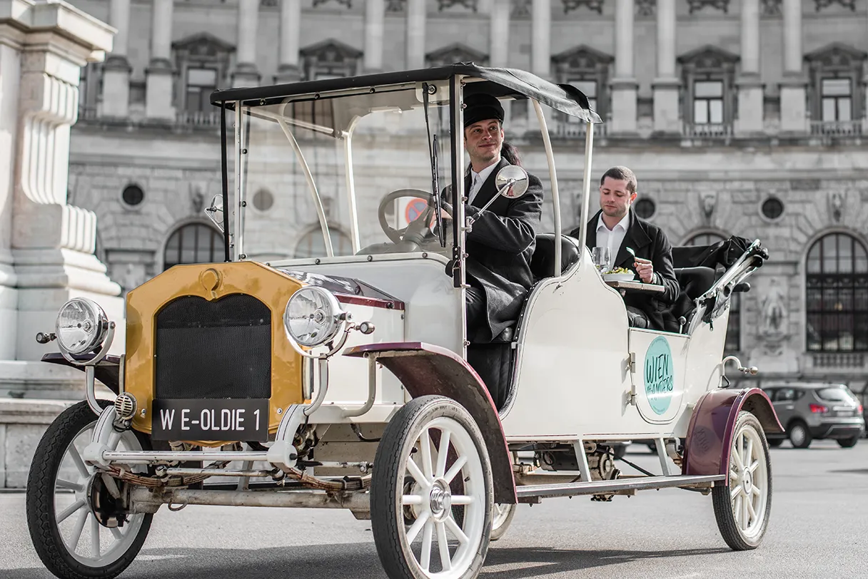 Elektroauto mit Wien mal anders. Das historische Gefährt steht auf dem Heldenplatz in Wien, bereit eine Tour zu fahren.