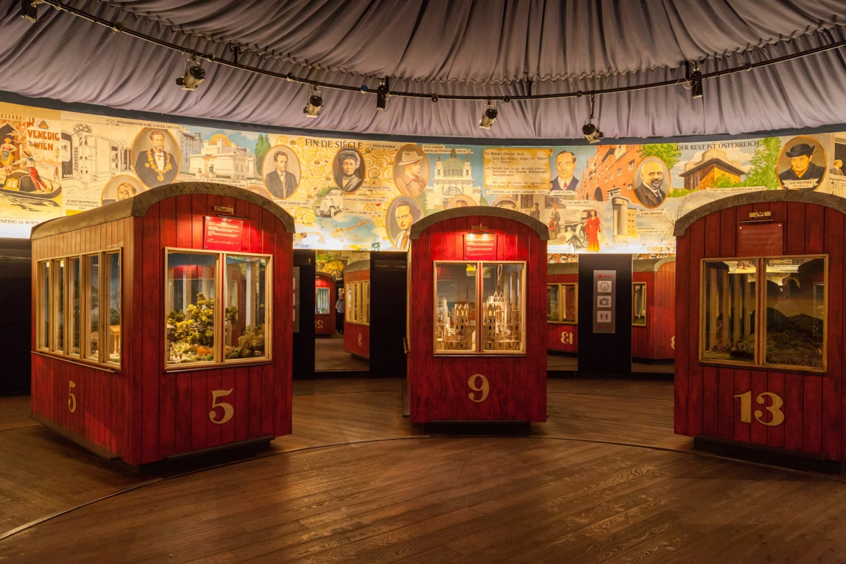Exhibition of the old Vienna Ferris wheel cars. Red cars are lined up side by side in a circle and feature fascinating information about the history of the Vienna Ferris wheel.