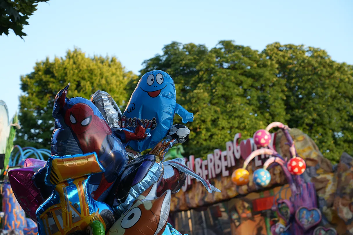 A colorful bouquet full of colorful balloons in the Prater Vienna, in the background you can see the Silberbergwerk ride