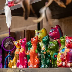 Flea market, colorful cats probably made of wood are lined up next to each other on the flea market table