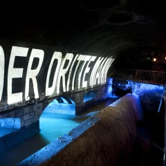 3rd Man Tour, Vienna, view into the Viennese underworlds, canal system, “The Third Man” is written on the wall, water is illuminated blue