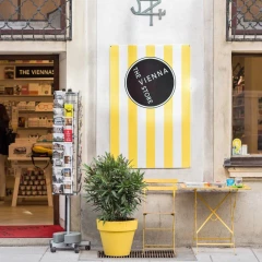 View into the Hamtil & Söhne store. Exterior facade. A card stand in front of the door. Various souvenirs can be seen in the store.