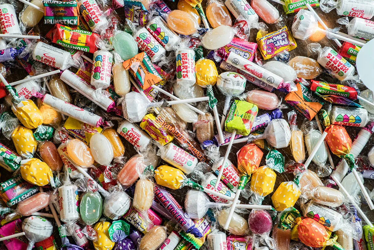 Sweets, lollipops, lollipops, sweets lie next to each other on a table, you can't see anything other than the sweets