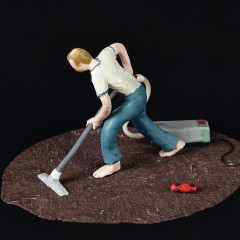 Exhibit at the Vienna Cathedral Museum. A small plasticine figure is holding a vacuum cleaner and vacuuming the floor.