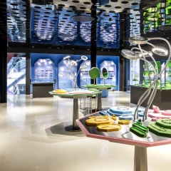 A view inside the Swarovski Crystal Worlds store in Vienna. Various display cases line the wall, showcasing a variety of crystals. In the foreground is a table with various exhibits on it.